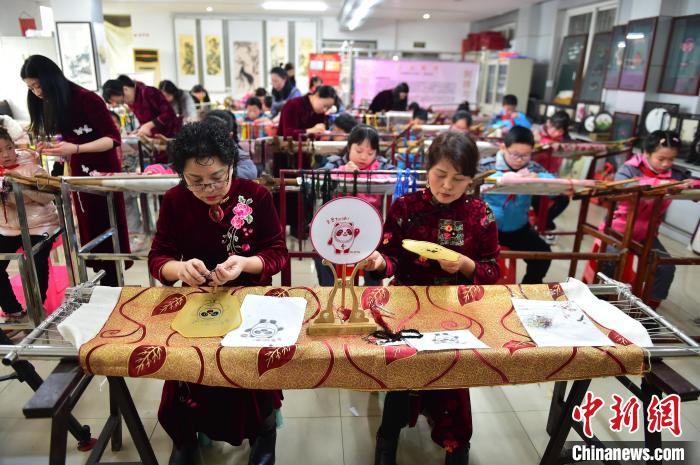江西省級非遺豫章繡傳承人手把手指導(dǎo)小學(xué)生繡制2022年北京冬奧會吉祥物“冰墩墩”形象?！∮髟屏?攝