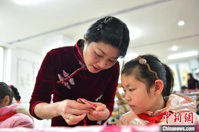 江西省級非遺豫章繡傳承人手把手指導(dǎo)小學(xué)生繡制2022年北京冬奧會吉祥物“冰墩墩”形象?！∮髟屏?攝