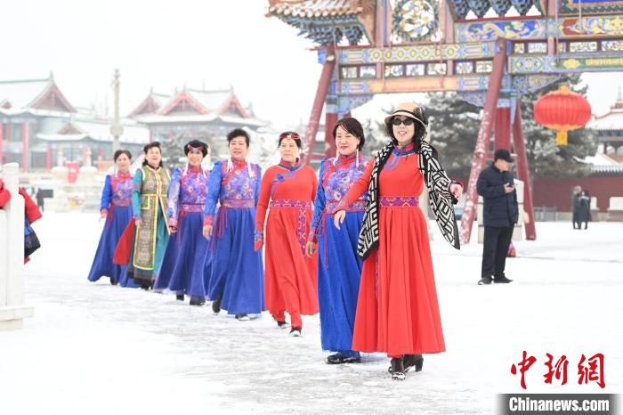 2月13日，老年人在呼和浩特市大召?gòu)V場(chǎng)拍照“打卡”?！⑽娜A 攝
