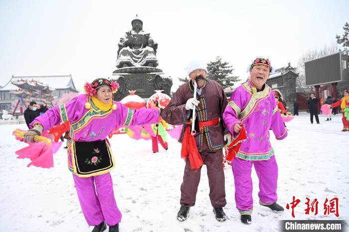2月13日，秧歌隊(duì)在呼和浩特市大召?gòu)V場(chǎng)雪中起舞。　劉文華 攝