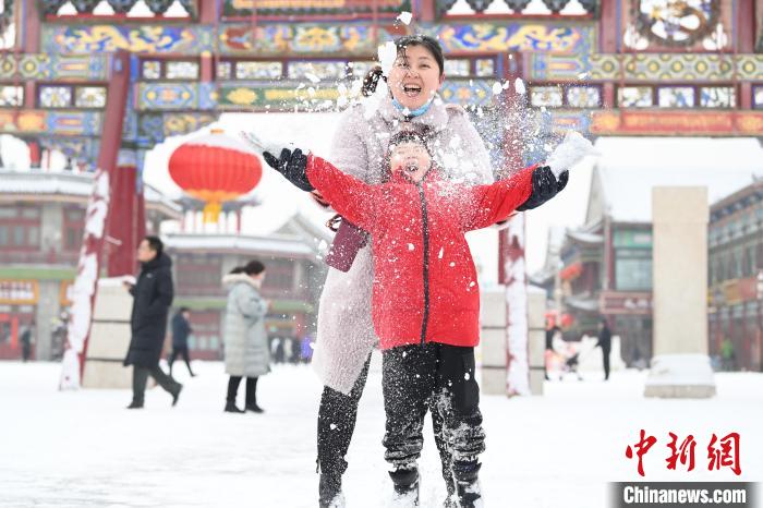 2月13日，家長(zhǎng)與小朋友在呼和浩特市大召?gòu)V場(chǎng)享雪趣。　劉文華 攝