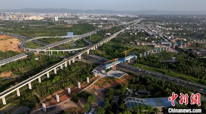 航拍正在建設(shè)的跨越成都繞城高速公路連續(xù)梁施工現(xiàn)場，旁邊依次為已運營的成渝高速鐵路和機場高速公路?！⒅铱?攝