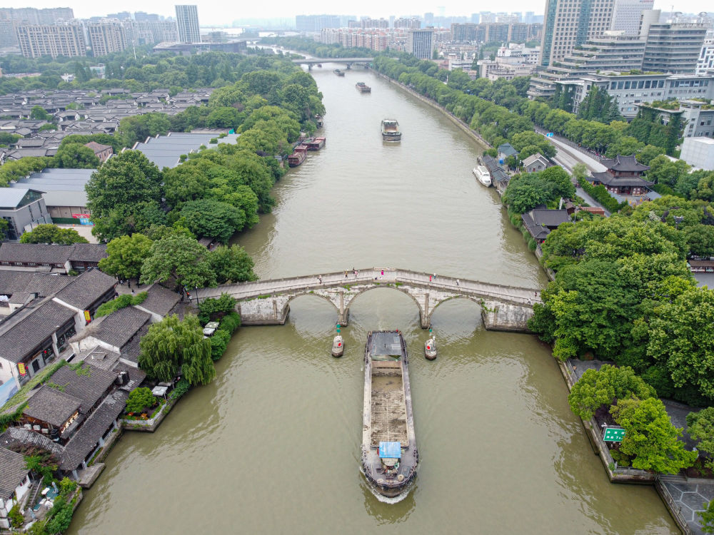 5月27日，一艘貨船駛過京杭大運(yùn)河南端標(biāo)志建筑杭州拱宸橋。(無人機(jī)照片)新華社記者江漢 攝
