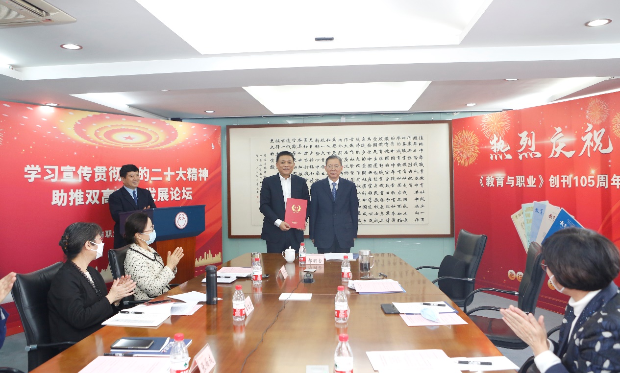 郝明金為《教育與職業(yè)》雜志編委代表陳曉明頒發(fā)聘書。中華職教社供圖