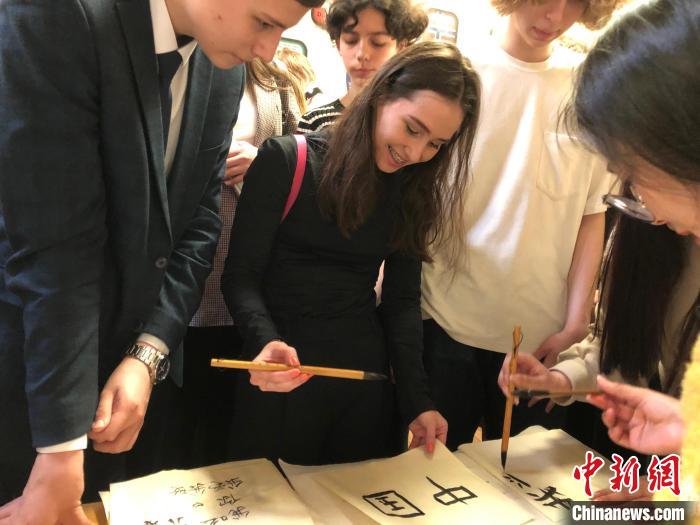 4月21日，莫斯科國立語言大學(xué)孔子學(xué)院附屬中學(xué)舉辦“國際中文日”活動(dòng)，學(xué)生們學(xué)寫漢字?！∧箍茋⒄Z言大學(xué)孔子學(xué)院 供圖