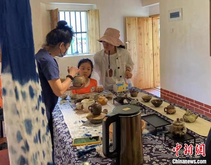 圖為：游客正在咨詢臺(tái)灣柴燒作品?！∪~秋云 攝