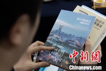 參展觀眾閱讀浙江文旅手冊?！《≌裾?攝