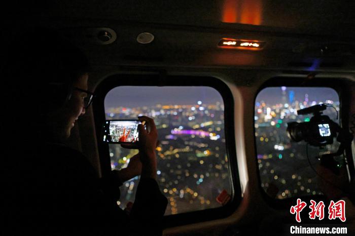 6月3日晚，游客乘坐上海新空直升機(jī)有限公司直升機(jī)開(kāi)啟鳥(niǎo)瞰黃浦江空中圓夢(mèng)之旅，并用手機(jī)拍攝城市夜景。　殷立勤 攝