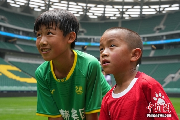 圖為北京國安小球員陳小北和7歲的俄金仁增在一起觀看場內(nèi)播放的紀(jì)錄片。<a target='_blank' href='/' _fcksavedurl='/'><p  align=
