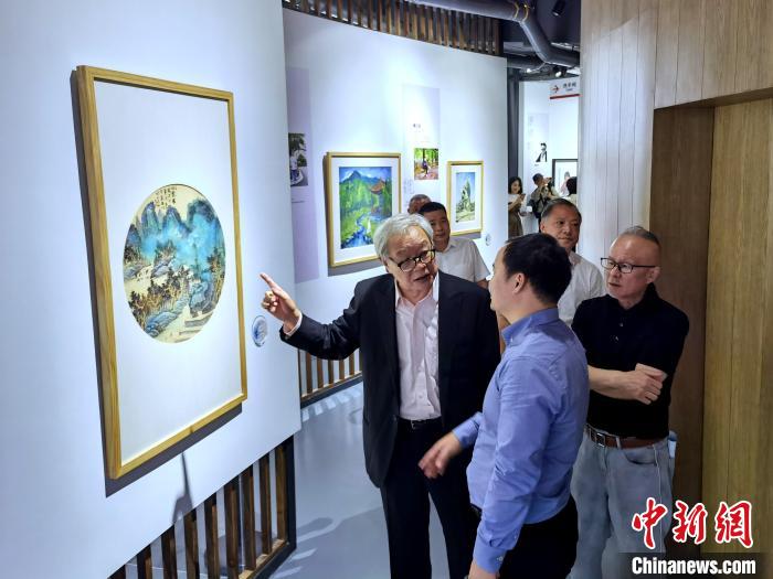 海峽兩岸藝術(shù)家畫展上，藝術(shù)家進(jìn)行藝術(shù)交流?！「毒窜?攝