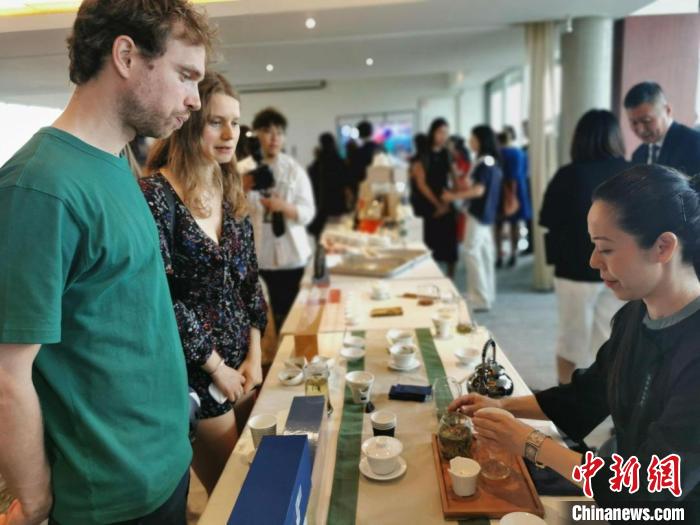 現(xiàn)場觀眾觀看中國展臺茶藝表演、了解茶文化。　靖樹 攝