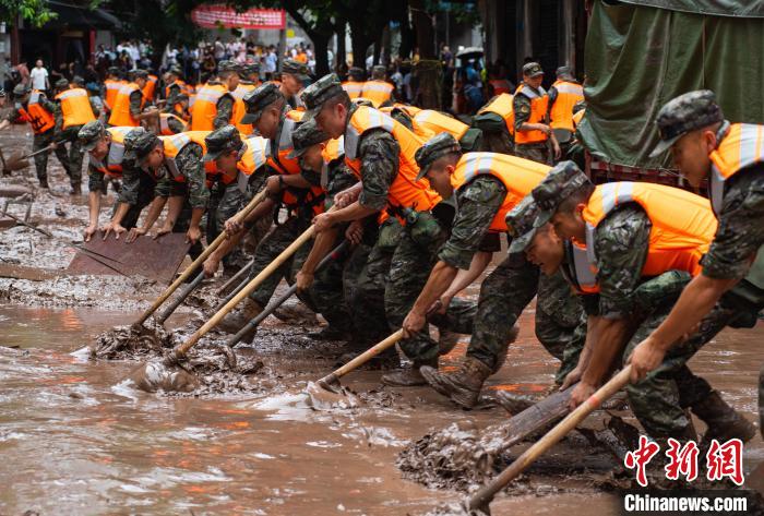 7月4日，萬(wàn)州區(qū)五橋街道，武警官兵清理街道上的淤泥?！∪矫宪?攝