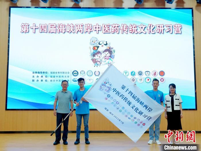 共青團(tuán)福建省委副書記吳雪(右一)、福建中醫(yī)藥大學(xué)黨委副書記林羽(左一)為兩岸學(xué)生代表頒授營旗。　許燁婷 攝