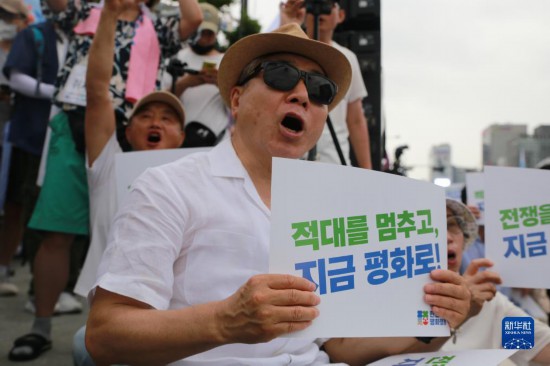 7月22日，在韓國首爾，人們手舉標(biāo)語參與反戰(zhàn)游行。新華社發(fā)（楊暢 攝）