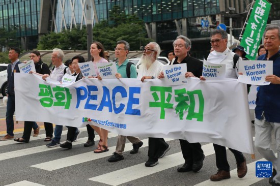7月22日，在韓國首爾，人們手舉標(biāo)語參與反戰(zhàn)游行。新華社發(fā)（楊暢 攝）