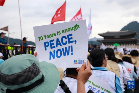 7月22日，在韓國首爾，人們手舉標(biāo)語參與反戰(zhàn)游行。新華社發(fā)（楊暢 攝）