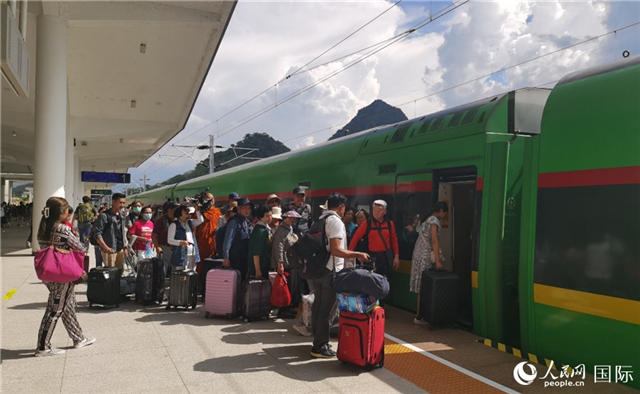 乘坐中老鐵路國際旅客列車的旅客在老撾瑯勃拉邦站排隊(duì)上車。人民網(wǎng)記者 杜明明攝