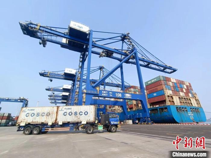 圖為海南洋浦國(guó)際集裝箱碼頭，卡車將集裝箱從后方堆場(chǎng)運(yùn)往碼頭裝卸區(qū)。　張?jiān)潞?攝