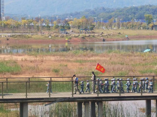 　　10月24日，秋游的幼兒園小朋友在老師帶領(lǐng)下走在清水塘公園里的木橋上。本報記者 常雯宜攝