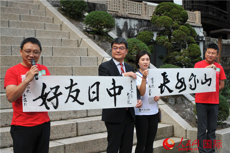 東京中國文化中心主任羅玉泉展示其為本次活動書寫的題詞“中日友好，山高水長”。人民網(wǎng) 蔣曉辰攝