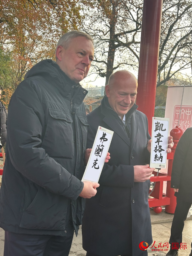 柏林市長(zhǎng)韋格納（右）、動(dòng)物園監(jiān)事會(huì)主席布魯克曼（左）手持中國(guó)文化中心工作人員現(xiàn)場(chǎng)手書的中文名字。人民網(wǎng)記者 徐馨攝