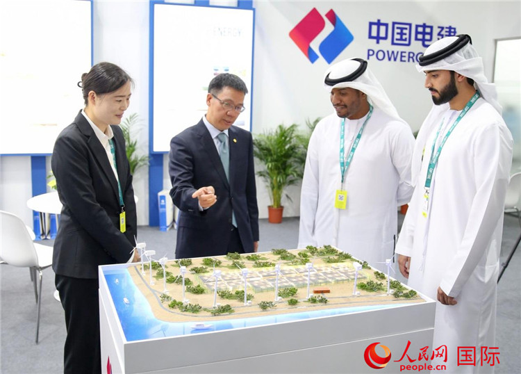 訪客在中國電建展臺參觀風(fēng)電項目沙盤。人民網(wǎng) 塔里克·易卜拉欣攝