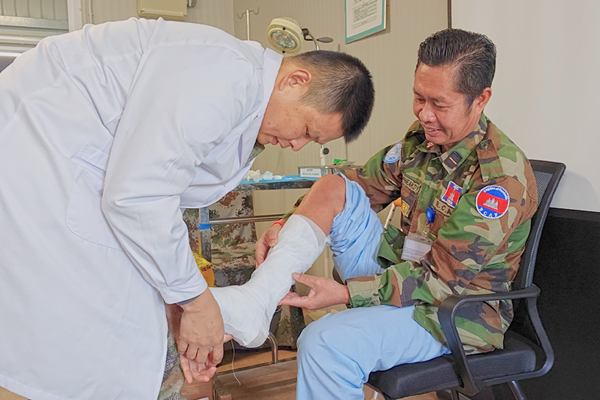 中國第22批赴黎維和醫(yī)療分隊軍醫(yī)為患者打石膏固定患肢。李清竹攝