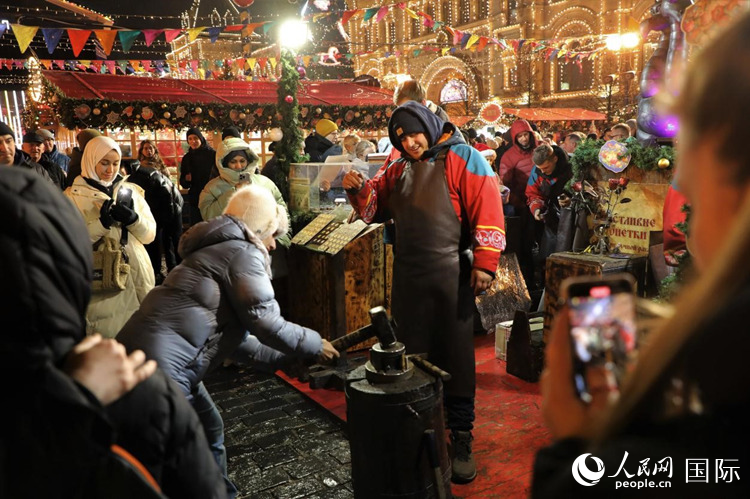 游客在新年集市上體驗(yàn)制作紀(jì)念幣。人民網(wǎng)記者 隋鑫攝