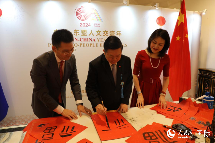東盟秘書長高金洪（中）在活動現(xiàn)場寫福字。人民網(wǎng)記者曹師韻攝