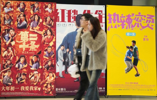 這是2月17日，在沈陽一家影院，觀眾從海報前經(jīng)過。新華社記者李鋼攝