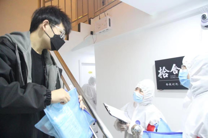 社區(qū)工作人員和志愿者身穿防護服上門送馬應(yīng)龍大健康防疫包。徐帥攝