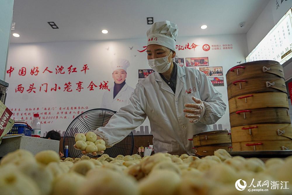 3月31日，在浙江省嵊州市甘霖鎮(zhèn)，嵊州小吃從業(yè)者沈紅平把蒸熟的小籠包晾涼，打包冷藏售賣(mài)。人民網(wǎng) 章勇濤攝