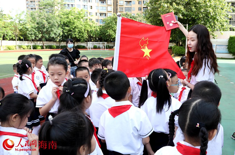 老師向少先隊(duì)員展示隊(duì)旗。人民網(wǎng) 符武平攝