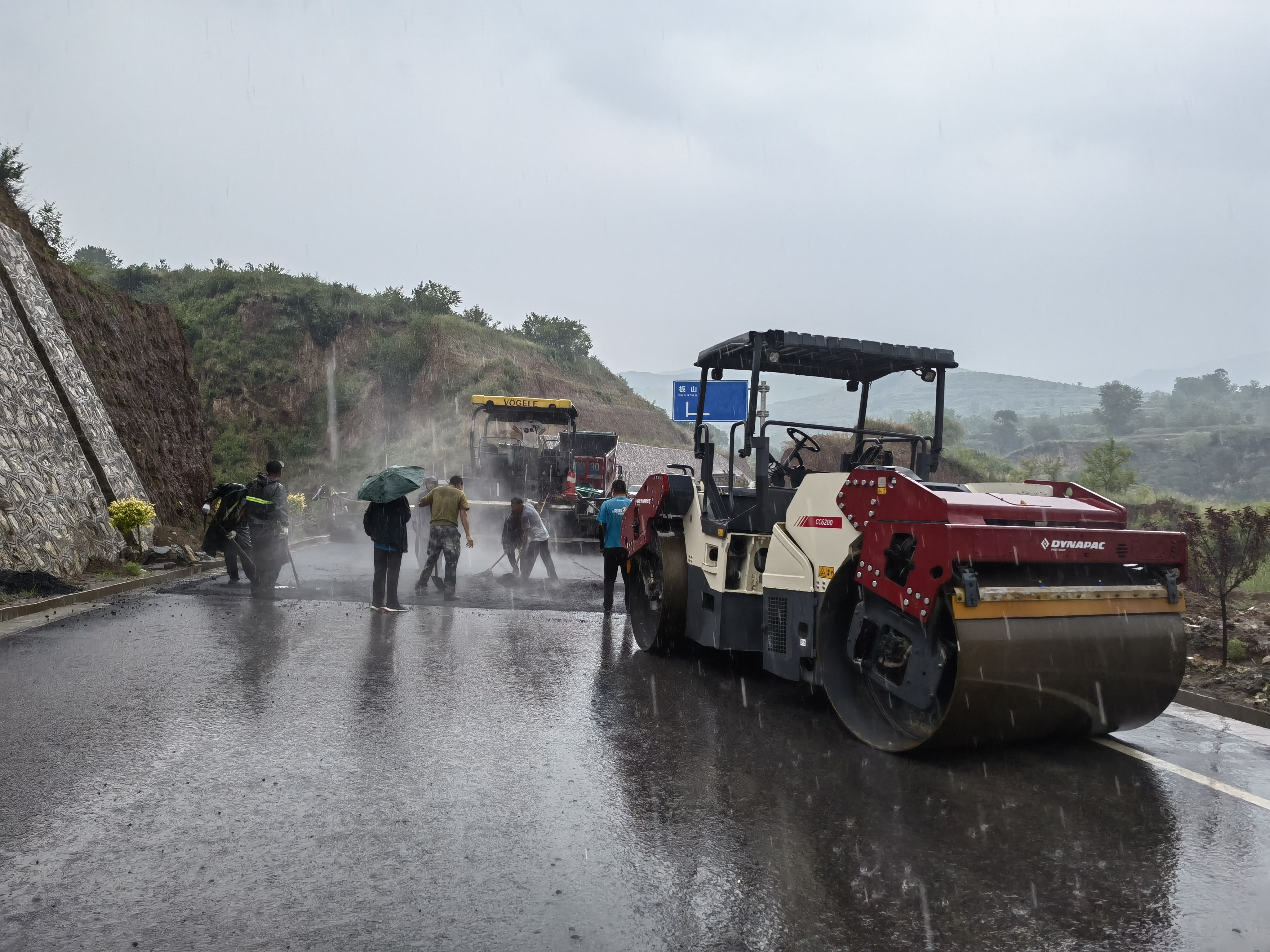 路橋工人在大雨中搶修道路。李華英 攝