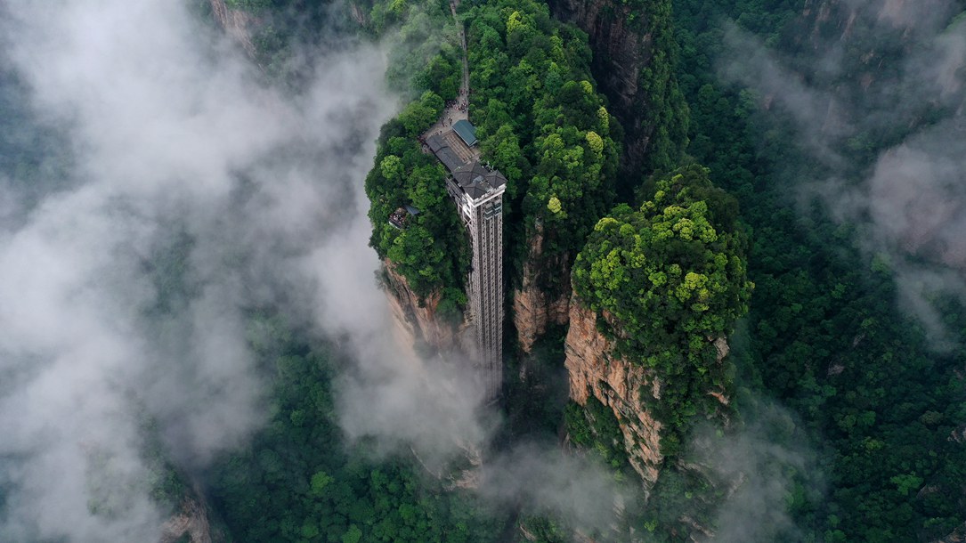 位于張家界武陵源景區(qū)的百龍?zhí)焯蓁偳对谠旗F繚繞的峰林間，雄偉壯觀。吳勇兵攝