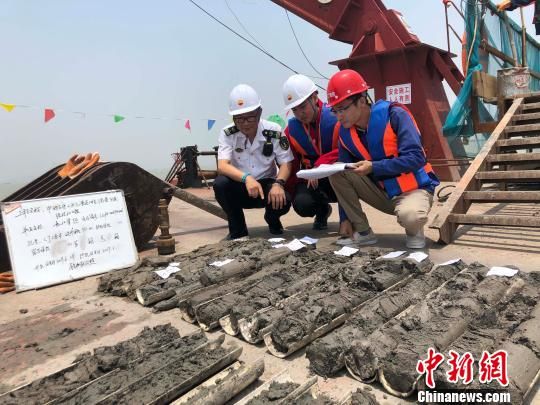 圖為勘察設(shè)計(jì)人員與海事局工作人員查看巖芯情況?！∥赫?攝