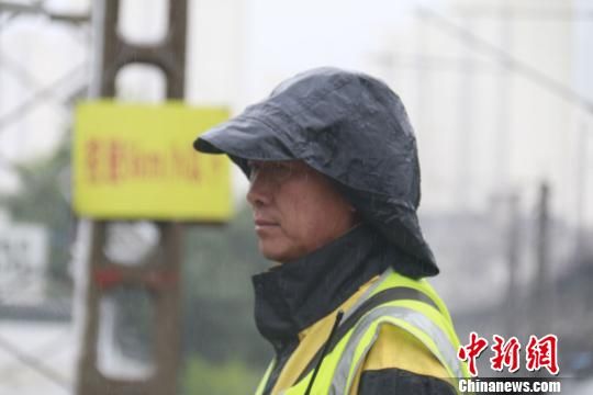 蘭州西工務(wù)段蘭州線路車間防護(hù)員雨中巡查?！⊥豕廨x 攝