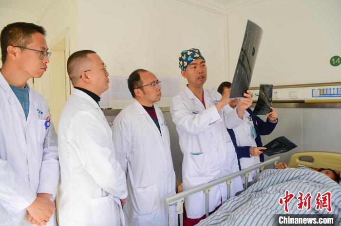 圖為醫(yī)療援藏專家何蔚(站右二)與馮敬云(左二)、廖濤(左三)等人討論患者病情。(資料圖) 貢嘎來(lái)松 攝