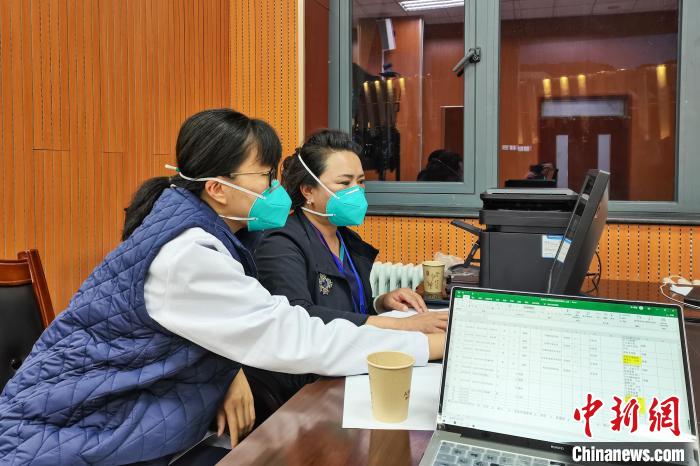 8月9日，楊蘇喬(左)在拉薩方艙醫(yī)院指揮部讀取艙內(nèi)患者胸部CT。　受訪者供圖