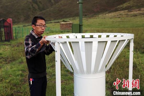 圖為班瑪縣氣象局工作人員在維護(hù)藏雪茶基地氣候站。青海省氣象局供圖