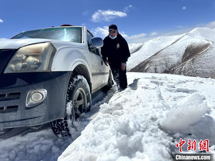 圖為生態(tài)管護人員準備在雪地推車?！《“瓦_杰 攝