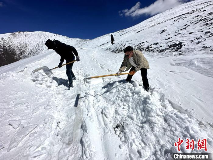 圖為生態(tài)管護人員在巡護道路上清雪。　丁巴達杰 攝
