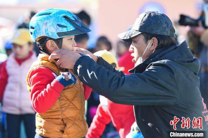 圖為拉薩市實驗幼兒園孩子在教練的幫助下穿戴頭盔?！『闻罾?攝