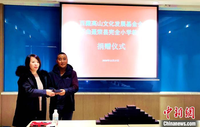 圖為西藏高山文化發(fā)展基金會理事長溫麗向聶榮縣完全小學(xué)負責(zé)人捐助儀器。　于賓 攝