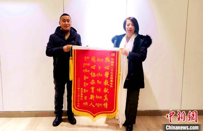 圖為聶榮縣完全小學(xué)向西藏高山文化發(fā)展基金會贈送錦旗?！∮谫e 攝