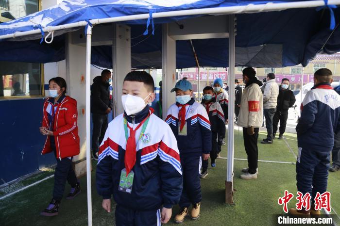 圖為學生測量體溫后進入校園?！●R銘言 攝