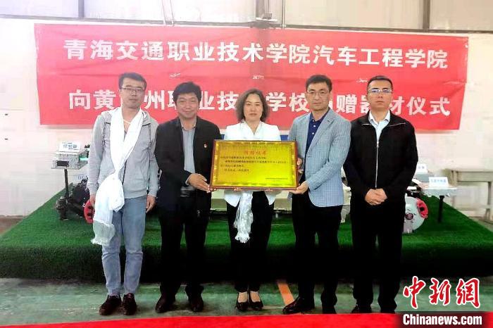圖為李富香(中)代表學(xué)校為州縣技校捐贈(zèng)器材。(資料圖) 青海省教育廳供圖