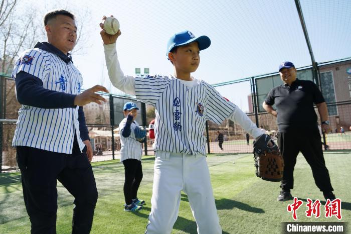 圖為教練指導(dǎo)小棒球手?jǐn)S球技術(shù)?！●R銘言 攝