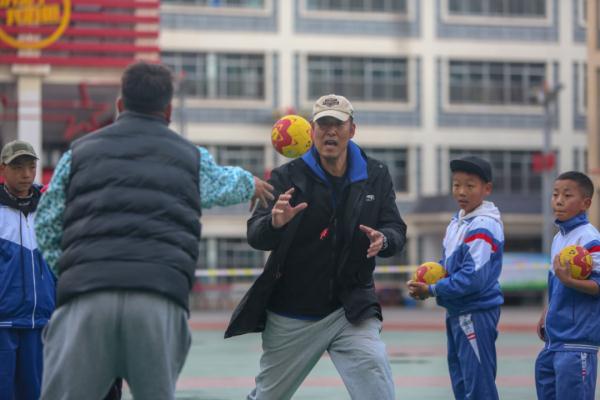 在高原上教孩子們打手球，“慢慢兒來，甭著急！”