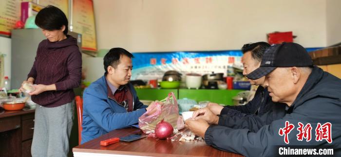 圖為扶貧路上“臨時(shí)一家人”準(zhǔn)備午餐?！∥航ㄜ?攝